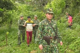 Lực lượng Bộ đội Biên phòng áp giải một đối tượng có hành vi mua bán người. (Ảnh: TTXVN phát)