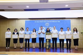 Lãnh đạo thành phố Hà Nội trao bằng khen cho các cá nhân có thành tích xuất sắc. (Ảnh: TTXVN phát)