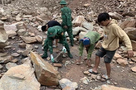 Chính quyền địa phương, lực lượng bộ đội biên phòng khắc phục các điểm sạt lở trên tuyến đường tỉnh 543D. (Ảnh: TTXVN phát)