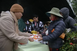 Tại gian hàng đầu tiên của phiên chợ 0 đồng, khi người dân xuất trình phiếu sẽ được 'mừng tuổi' 100.000 đồng. (Ảnh: Thanh Thủy/TTXVN)