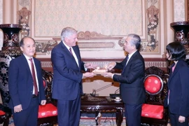 Phó Chủ tịch UBND Thành phố Hồ Chí Minh Ngô Minh Châu - thứ hai từ phải sang tặng quà lưu niệm cho Mục sư Franklin Graham - thứ 2 từ trái sang. (Ảnh: Xuân Khu/TTXVN)