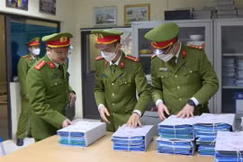 Công an niêm phong, thu giữ hồ sơ, tài liệu tại một trung tâm đăng kiểm. (Ảnh: TTXVN phát)