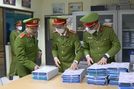 Công an niêm phong, thu giữ hồ sơ, tài liệu tại một trung tâm đăng kiểm. (Ảnh: TTXVN phát)