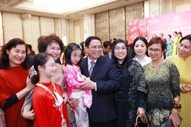 Thủ tướng Phạm Minh Chính và Phu nhân với cộng đồng người Việt Nam tại Singapore. (Ảnh: Dương Giang/TTXVN) 