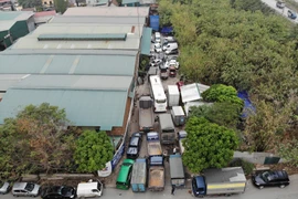 Hàng chục ôtô nối đuôi xếp hàng dài chờ đợi đến lượt khám xe. (Ảnh: Hoàng Hiếu/TTXVN)