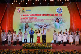 Phó Chủ tịch Tổng Liên đoàn Lao động Việt Nam Huỳnh Thanh Xuân (trái) cùng ông Nguyễn Hồ Hải, Phó Bí thư Thành ủy trao giải cho chị Nguyễn Thị Lệ Thủy, Tổ trưởng Tổ nuôi động vật thí nghiệm Trung tâm Công nghệ Sinh học Thành phố Hồ Chí Minh. (Ảnh: Thanh V