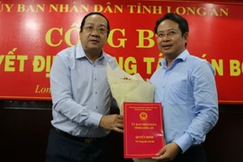 Phó Chủ tịch UBND tỉnh Long An Nguyễn Minh Lâm trao Quyết định bổ nhiệm Phó Giám đốc Sở Xây dựng cho ông Võ Anh Linh. (Ảnh: Thanh Bình/TTXVN)