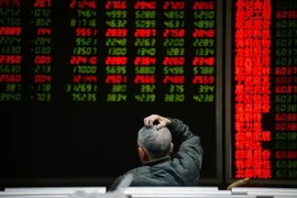 Nhà đầu tư theo dõi bảng chỉ số chứng khoán tại Bắc Kinh, Trung Quốc. (Ảnh: AFP/TTXVN)