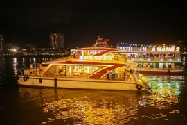 Các du thuyền đưa khách du lịch thưởng ngoạn cảnh đẹp trên sông Hàn về đêm và ngắm pháo hoa. (Ảnh: Trần Lê Lâm/TTXVN)