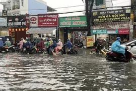 Nước ngập gần nửa bánh xe trên đường Lê Văn Thọ, quận Gò Vấp. (Ảnh: Hồng Giang/TTXVN)