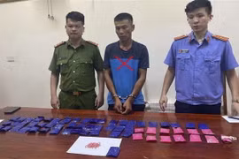 Đối tượng Vũ Văn Toản bị bắt giữ cùng tang vật. (Ảnh: TTXVN phát)