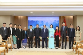 Thủ tướng Phạm Minh Chính với Tổng Giám đốc TTXVN Vũ Việt Trang và Tổng Giám đốc Thông tấn xã Pathet Lào (KPL) Khampheuy Philapha cùng các thành viên đoàn. (Ảnh: Dương Giang/TTXVN)