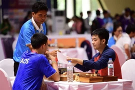 Kỳ thủ của Việt Nam (bên phải) thi đấu môn Cờ ốc gặp kỳ thủ của Lào trong ngày ra quân 29/4. (Ảnh: Minh Quyết/TTXVN) 