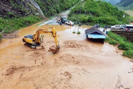 Máy múc được huy động để san gạt bùn, đất, đá bị sạt lở tại bản Nà Lếch, xã Chiềng Lao, huyện Mường La. (Ảnh: Quang Quyết/TTXVN)