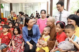 Phó Chủ tịch-Tổng Thư ký Ủy ban Trung ương Mặt trận Tổ quốc Việt Nam Nguyễn Thị Thu Hà thăm hỏi trẻ mồ côi tại chùa. (Ảnh: Minh Đức/TTXVN)