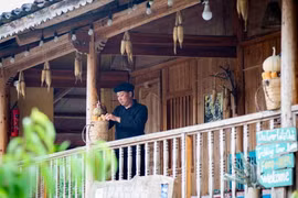Trưởng thôn Sình Dỉ Gai trang trí homestay của gia đình. (Ảnh: Nam Thái/TTXVN)