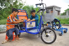 Không may bị dị tật bẩm sinh, khó khăn trong việc đi lại, nhưng anh Lê Văn Lịch (phải) ở xã Trường Yên, huyện Hoa Lư, tỉnh Ninh Bình là điển hình làm kinh tế ở địa phương nhờ việc làm xe lăn điện cho người khuyết tật, tạo việc làm cho những người khuyết t