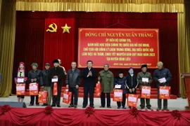 Ủy viên Bộ Chính trị Nguyễn Xuân Thắng - Giám đốc Học viện Chính trị Quốc gia Hồ Chí Minh trao quà cho các gia đình chính sách, người có công. (Ảnh: Thanh VânTTXVN)