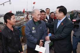 Chủ tịch Quốc hội Vương Đình Huệ tặng quà cho ngư dân tại Khu neo đậu tàu thuyền Cửa Phú. (Ảnh: Doãn Tấn/TTXVN)