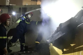 Lực lượng chức năng chữa cháy tại ngôi nhà cấp 4 ở K325/H99/18 đường Hùng Vương lúc 1 giờ 30 phút ngày 25/2. (Ảnh: TTXVN phát)