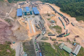 Các phương tiện không có bãi đỗ phải xếp hàng dài dọc khu vực cửa khẩu kéo dài đến Quốc lộ 15D về phía Việt Nam và Lào để chờ làm thủ tục xuất nhập cảnh. (Ảnh: Thanh Thủy/TTXVN)