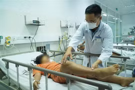 Bác sỹ Bệnh viện Chợ Rẫy thăm khám cho bệnh nhi ngộ độc Botulinum. (Ảnh: TTXVN phát)