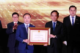 Phó Thủ tướng Trần Lưu Quang (bên phải) trao Huân chương Lao động hạng Nhì của Chủ tịch nước tặng Học viện Tư pháp. (Ảnh: Phạm Kiên/TTXVN)