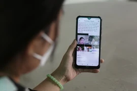 Một người vay nợ 'tín dụng đen' bị đăng ảnh kèm thông tin lên mạng xã hội để tạo áp lực trả tiền. (Ảnh: Giang Phương/TTXVN)