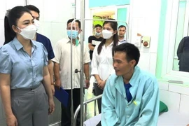 Phó Chủ tịch UBND huyện Xín Mần Vũ Thị Hòa thăm hỏi, động viên các bệnh nhân bị ngộ độc do ăn hoa chuông. (Ảnh: TTXVN phát)