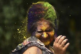 Một phụ nữ hứng được đủ thứ bột đầy màu sắc tại Lễ hội sắc màu Holi ở Mumbai, Ấn Độ ngày 7/3. (Ảnh: AFP/TTXVN)