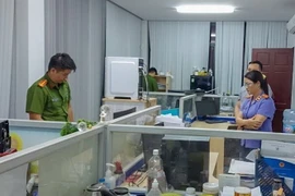 Công an thành phố Cần Thơ thực hiện lệnh khám xét tại tại Chi cục đăng kiểm số 8. (Ảnh: TTXVN phát)