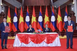 Thủ tướng Phạm Minh Chính và Thủ tướng Lào Sonexay Siphandone chứng kiến lễ ký Hiệp định tương trợ tư pháp dân sự giữa Việt Nam và Lào. (Ảnh: Dương Giang/TTXVN)