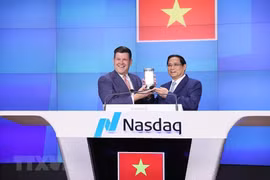 Phó Chủ tịch Tập đoàn Nasdaq Robert H.McCooey Jr tặng kỷ niệm chương của Nasdaq cho Thủ tướng Phạm Minh Chính. (Ảnh: Dương Giang/TTXVN)