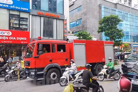 Lực lượng chức năng có mặt để khống chế đám cháy. (Ảnh: Hoài Nam/Vietnam+)