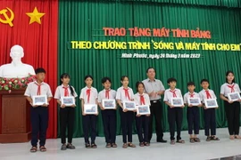 Trao máy tính bảng cho cho các em học sinh có hoàn cảnh khó khăn, vượt khó vươn lên trong học tập trên địa bàn huyện Ninh Phước. (Ảnh: Công Thử/TTXVN)