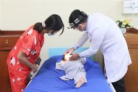 Bác sỹ hướng dẫn người nhà bệnh nhi cách chăm sóc mũi cho bé sau ca phẫu thuật. (Ảnh: Chanh Đa/TTXVN)