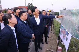 Bí thư Thành ủy Hà Nội Đinh Tiến Dũng kiểm tra thực địa tại địa điểm chân cầu Hồng Hà, khu vực đê Hữu Hồng, xã Hồng Hà, huyện Đan Phượng. (Ảnh: Văn Điệp/TTXVN)