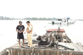 Lực lượng chức năng làm việc với ông Trần Văn Tèo Nhỏ tại hiện trường. (Ảnh: TTXVN phát)