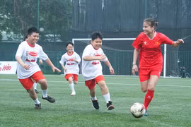 Tuyển thủ Bóng đá Nữ Thái Thị Thảo (áo đỏ) trong trận giao hữu với các bạn nhỏ thuộc Làng trẻ em SOS. (Ảnh: Việt Anh/Vietnam+)
