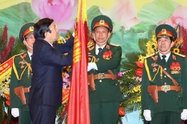 Chủ tịch nước Trương Tấn Sang gắn Huân chương Quân Công hạng Nhất lên Cờ truyền thống của Bộ Tổng tham mưu Quân đội nhân dân Việt Nam. (Ảnh: Nguyễn Khang /TTXVN) 