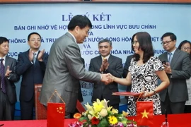 Lễ ký kết thỏa thuận hợp tác giữa Bộ Thông tin và Truyền thông Việt Nam với Tổng cục Bưu chính Quốc gia Trung Quốc. (Ảnh: Minh Quyết/TTXVN)