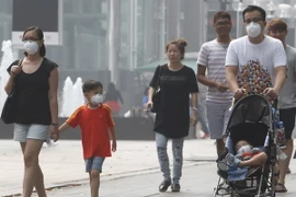 Người dân Singapore đeo khẩu trang để đối phó với tình trạng ô nhiễm khói bụi. (Nguồn: Reuters/TTXVN)
