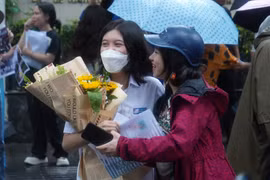 Phụ huynh chờ đón con em với bó hoa tươi thắm. (Ảnh: PV/Vietnam+)