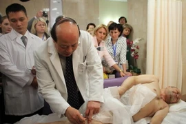 Phó ​giáo sư, ​tiến sỹ Nguyễn Hữu Thành, Giám đốc Bệnh viện châm cứu Trung ương trực tiếp châm cứu cho bệnh nhân. (Ảnh: Duy Trinh/Vietnam+)