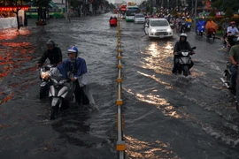 Đường Kinh Dương Vương (quận Bình Tân) ngập sâu hơn nửa mét làm nhiều phương tiện bị chết máy. (Ảnh: Mạnh Linh/TTXVN)