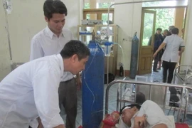 Lãnh đạo huyện Cô Tô tới thăm hỏi động viên ngư dân Tuấn. (Ảnh: Nguyễn Hoàng/Vietnam+)