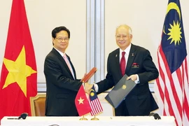 Thủ tướng Nguyễn Tấn Dũng và Thủ tướng Najib Razak ký Tuyên bố về Khuôn khổ quan hệ Đối tác chiến lược Việt Nam-Malaysia. (Ảnh: Đức Tám/TTXVN)