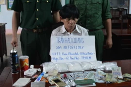 Đối tượng Quang cùng tang vật tại cơ quan điều tra. (Ảnh: Đậu Tất Thành/TTXVN)