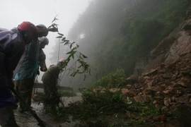 Công nhân Hạt Giao thông 4 thu dọn đất đá ở những điểm sạt lở trên tuyến đường lên Khu du lịch Mẫu Sơn. (Ảnh: Doãn Hoàng Nam/TTXVN)
