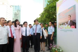 Các đại biểu tham quan triển lãm ảnh. (Ảnh: Thanh Vũ/TTXVN)